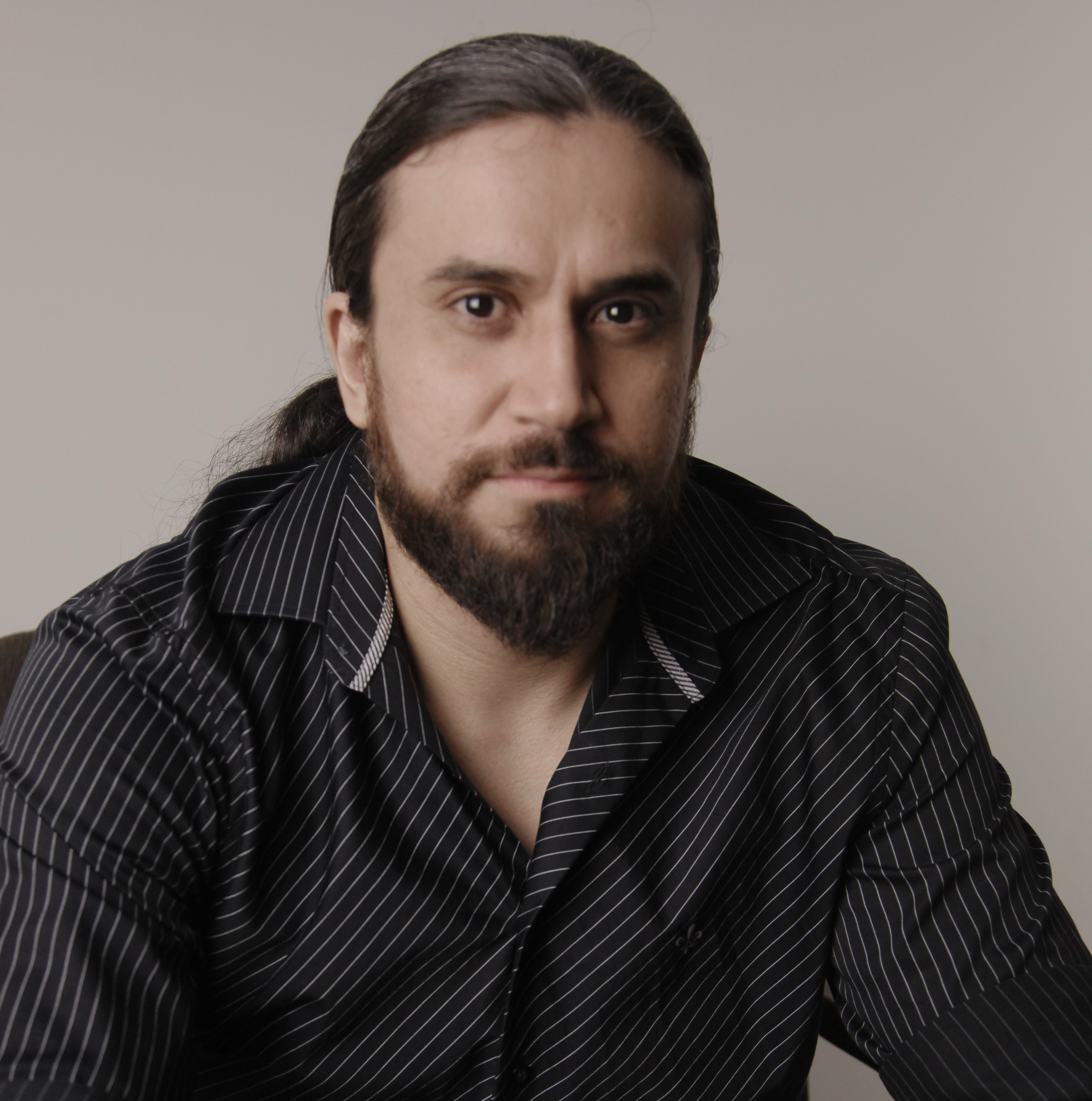 Retrato do Dr. Bruno Marinho de Sousa, psicólogo com doutorado em Psicobiologia, com camisa preta listrada e expressão neutra.